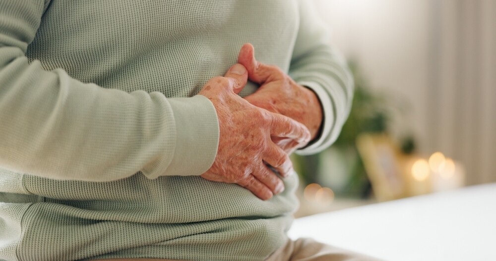 IBS vs. Colon Cancer 22 Hands, stomach pain with closeup and gut health, person has digestion issues and nutrition, with elderly care. Sick, colon, and gas with healthcare and wellness, help, and support for stress and illness